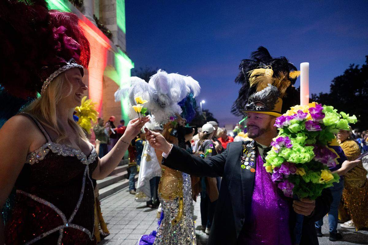 Float participants hand out flowers during a 12th Night Celebration in Biloxi on Monday, Jan. 5, 2026.