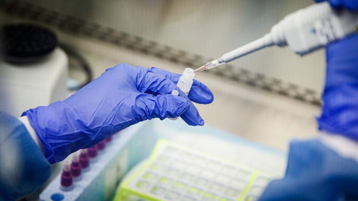 In this March 11, 2020, photo, a laboratory technician prepares COVID-19 patient samples for semiautomatic testing at Northwell Health Labs in Lake Success, N.Y.