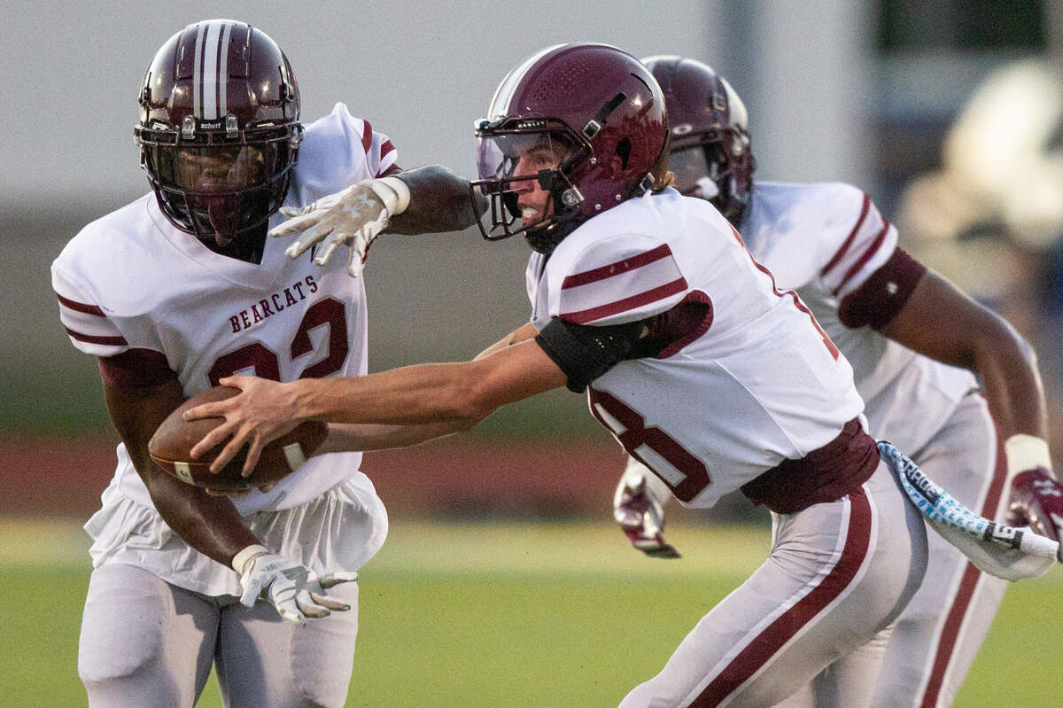 Long Beach’s Will Brady hands the ball off to Junior Brown during a game between Bay High and Long Beach at Tiger Stadium in Bay St. Louis on Friday, Sept. 13, 2024.