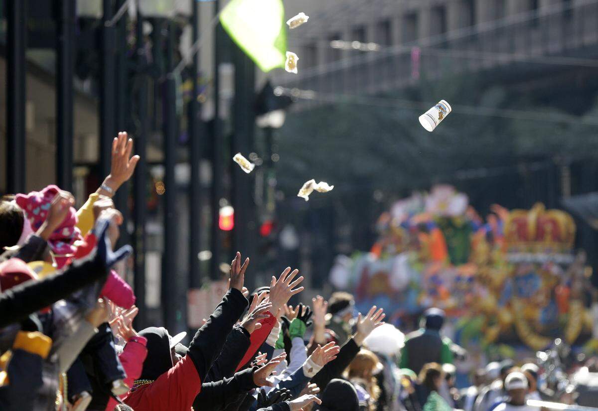 People reach for beads and trinkets during the Krewe of Rex parade on Mardi Gras in New Orleans, Tuesday, Feb. 17, 2015.