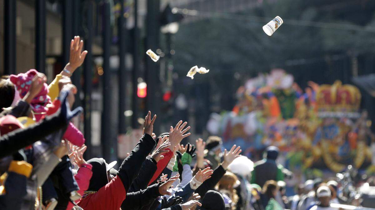 People reach for beads and trinkets during the Krewe of Rex parade on Mardi Gras in New Orleans, Tuesday, Feb. 17, 2015. Revelers in glitzy costumes filled the streets of New Orleans for the annual fat Tuesday bash, opening a day of partying and parades. (AP Photo/Gerald Herbert)