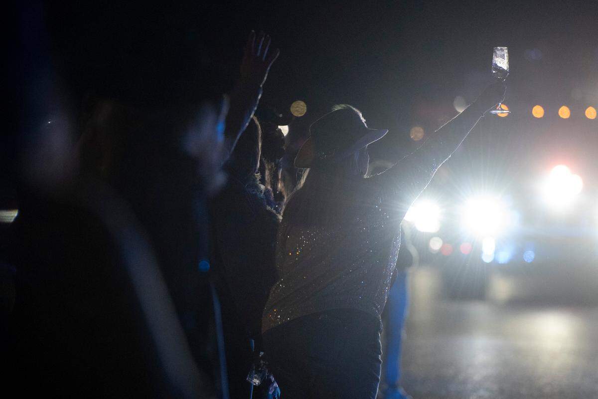 A parade attendee raises her wine glass as police lead Mystic Krewe of the Seahorse’s Lundi Gras parade down Beach Boulevard in Bay St. Louis on Monday, March 3, 2025.