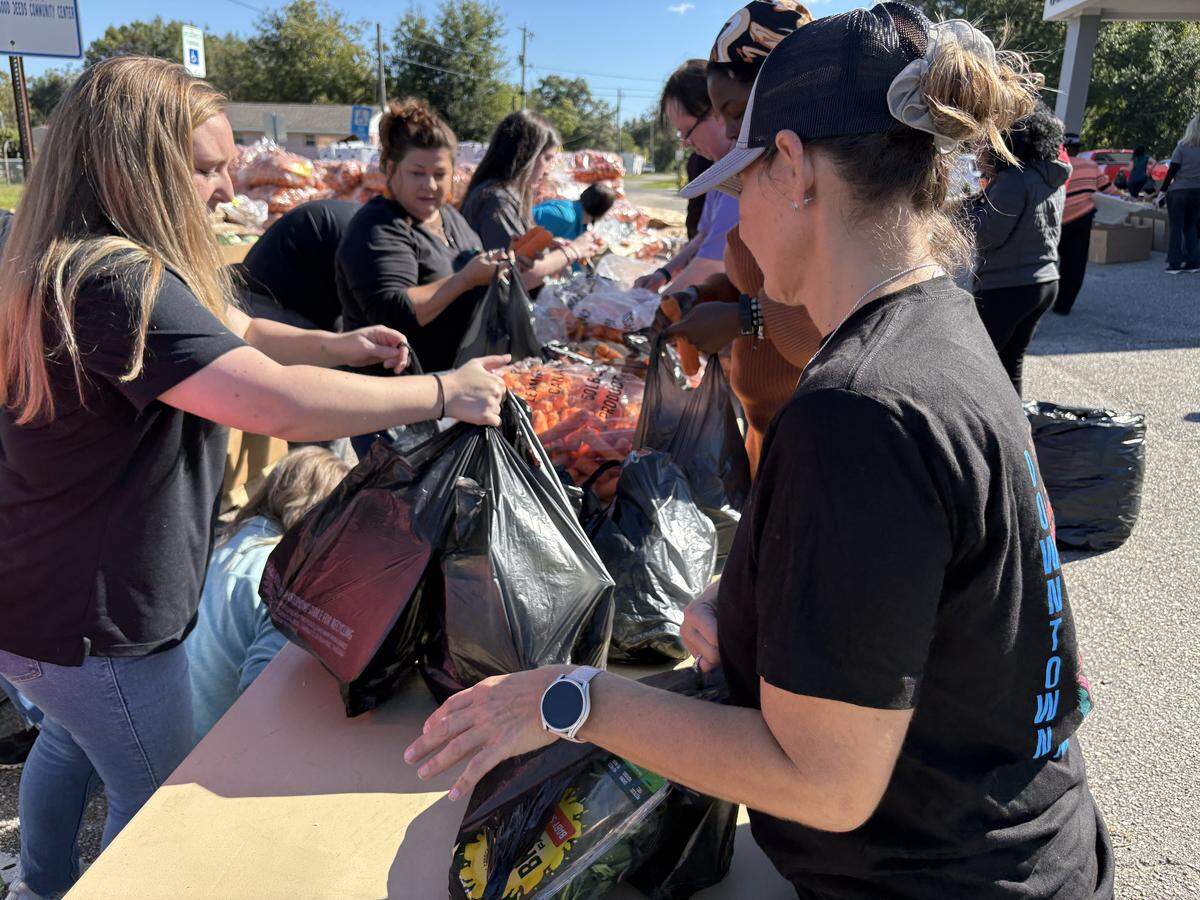 Volunteers sort food for a giveaway Friday at the Good Deeds Community Center in Gulfport. The event was sponsored by the nonprofit Extend a Hand, Help a Friend, Keesler Federal Credit Union, City Council members Carrissa Corbett and Kendall Buckner, and Harrison County Supervisor Kent Jones.