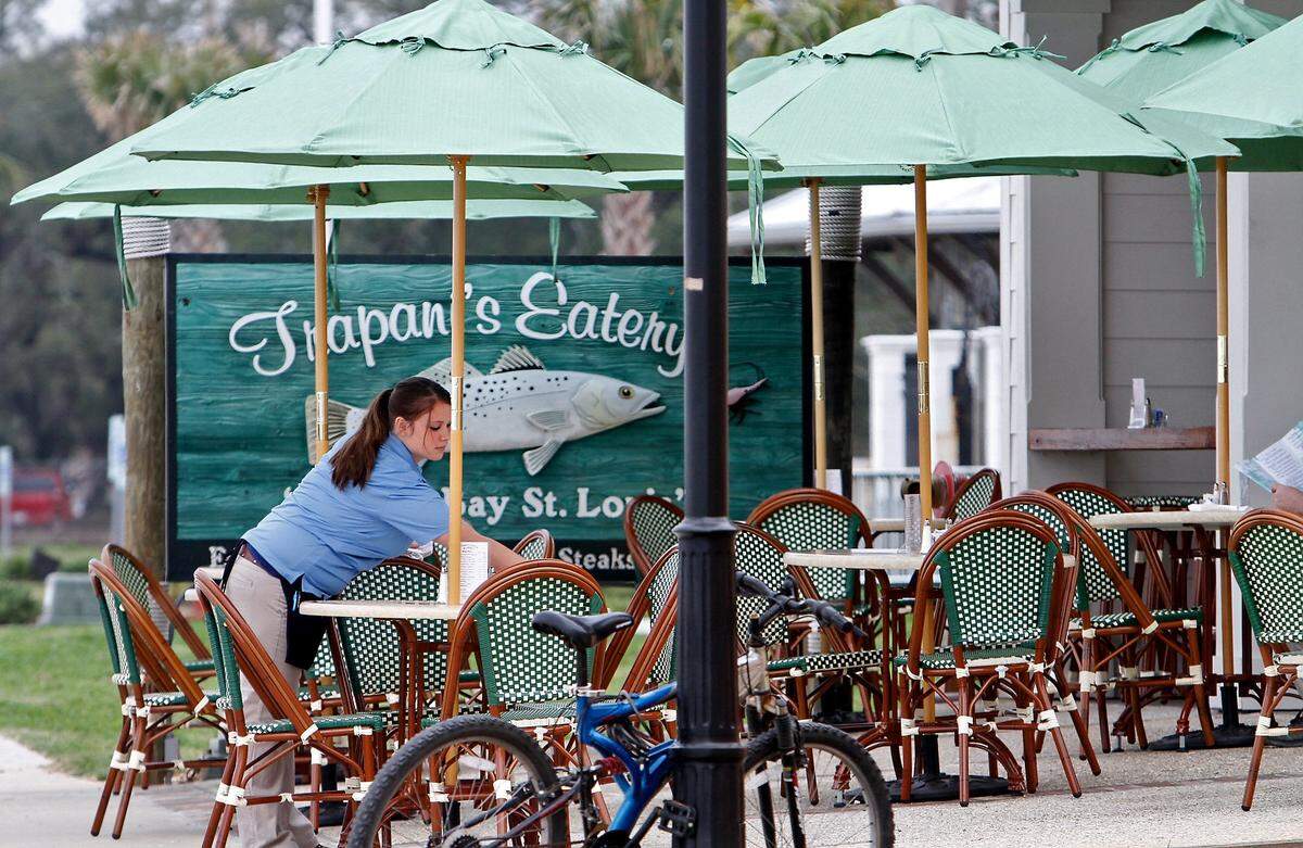 A waitress readies the outside patio of Trapani’s for its grand reopening on Wednesday, February 22 2012 in Bay St. Louis. The restaurant opened its doors at 11 a.m. at its original location on Beach Boulevard.