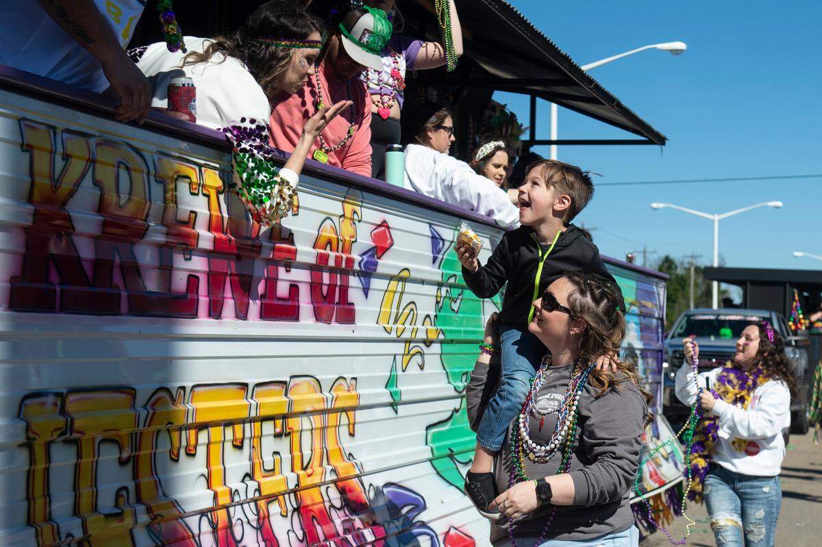 A float rider blows a kiss after tossing snacks from the float during the Krewe of Nereids Mardi Gras parade on Highway 90 in Bay St. Louis on Sunday, Feb. 12, 2023.