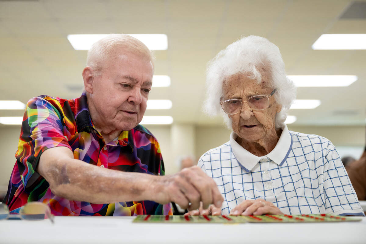 Tom Deters, left, helps Helen Calehuff, right, play bingo at the Lyman Senior Center on Tuesday.