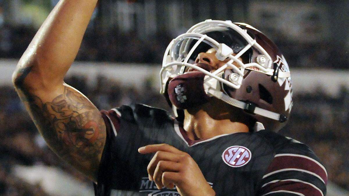 Mississippi State quarterback Dak Prescott (15) points skyward in remembrance of his mother after scoring a touchdown during the first half of an NCAA college football game against Kentucky in Starkville, Miss., Saturday, Oct. 24, 2015. (AP Photo/Jim Lytle)