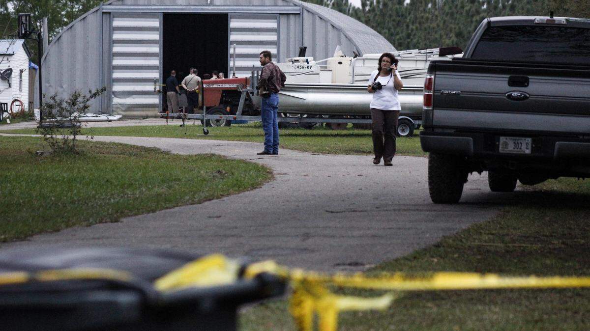 WESLEY MULLER/SUN HERALD 
 Officials gather near Nanny's Road and Jim Ramsey Road in Vancleave after the body of 16-year-old Cliff Allyn was found in the woods behind his grandmother's home on Thursday, March 31, 2016.