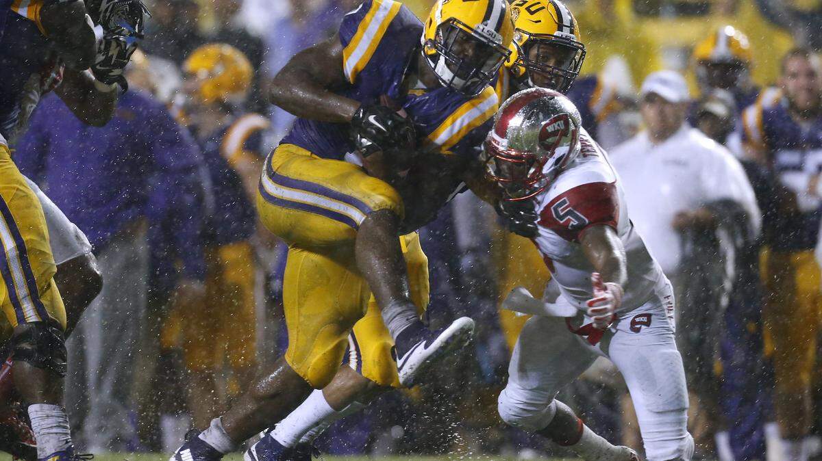 LSU running back Leonard Fournette, center, runs against Western Kentucky defensive back Wonderful Terry (5) during the first half an NCAA college football game in Baton Rouge, La., Saturday, Oct. 24, 2015. (AP Photo/Jonathan Bachman)