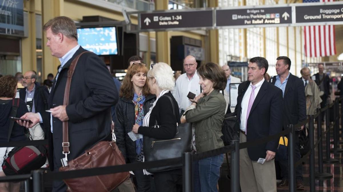 Passengers wait in a security line at Washington's Ronald Reagan National Airport in Washington, Friday, May 13, 2016.