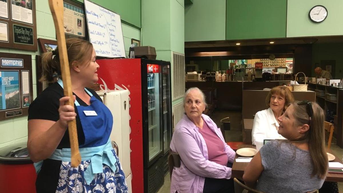 Wendy Fairley holds a big gumbo paddle during the Tasty Tours of South Mississippi visit to Triplett-Day Drugs in downtown Gulfport. Fairley and her sister, Jessica Adams, conduct the tours.