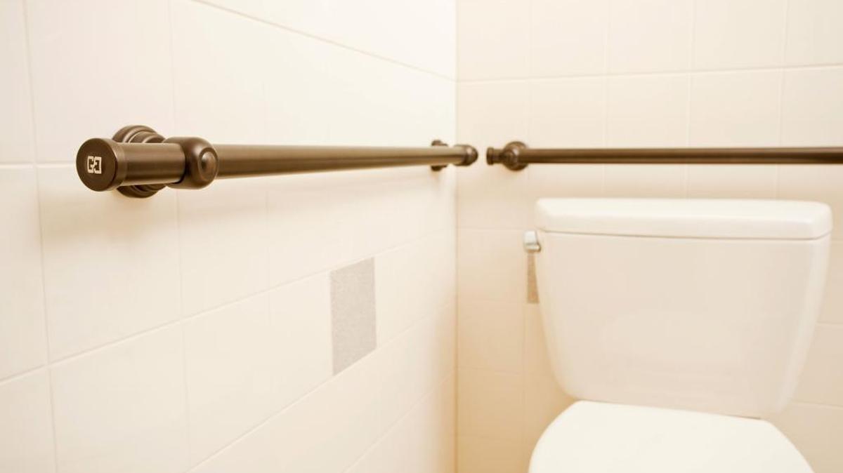 This photo provided by Best Bath Systems shows a grab bar in a brushed bronze finish placed in the toilet area of a bathroom. Most people think of grab bars for the shower and bathtub, but consider putting one near the toilet as well.