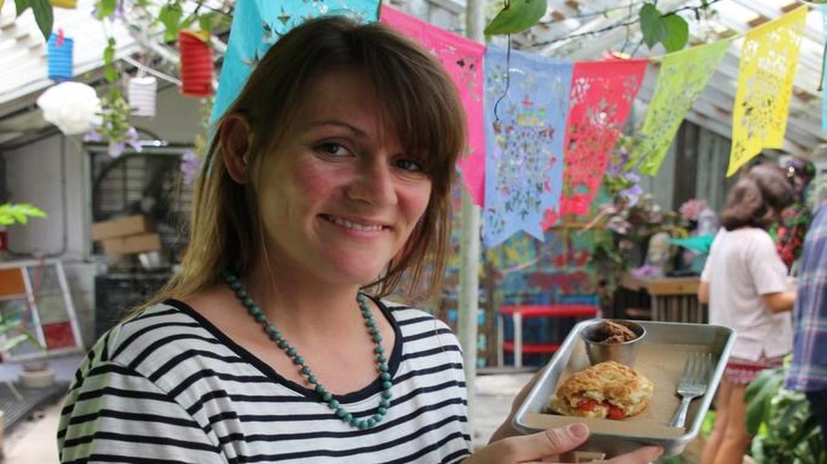 Co-owner of the Greenhouse on Porter in Ocean Springs, Kait Sukiennik, shows off one of her famous biscuits.