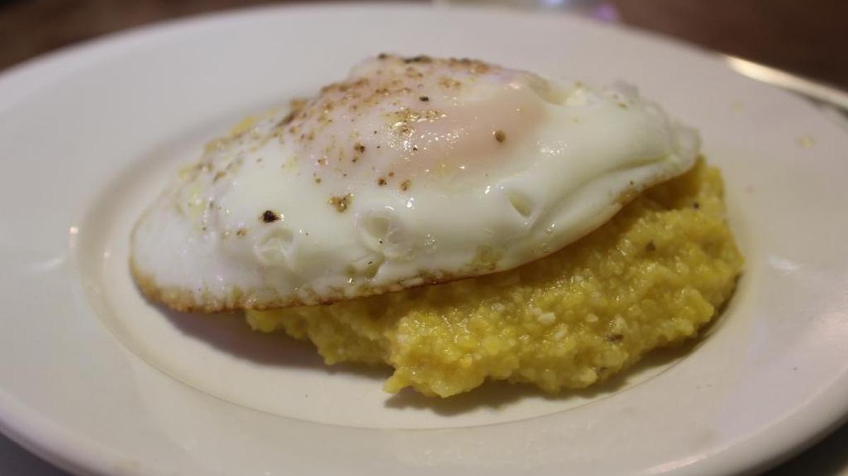 Yellow grits and a fried egg is a good combination any time, not just for breakfast.