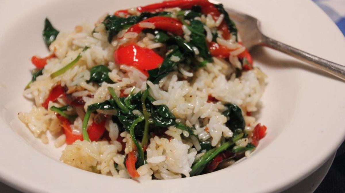 Greens, tomatos and rice, dressed with olive oil, is a great summertime dish.