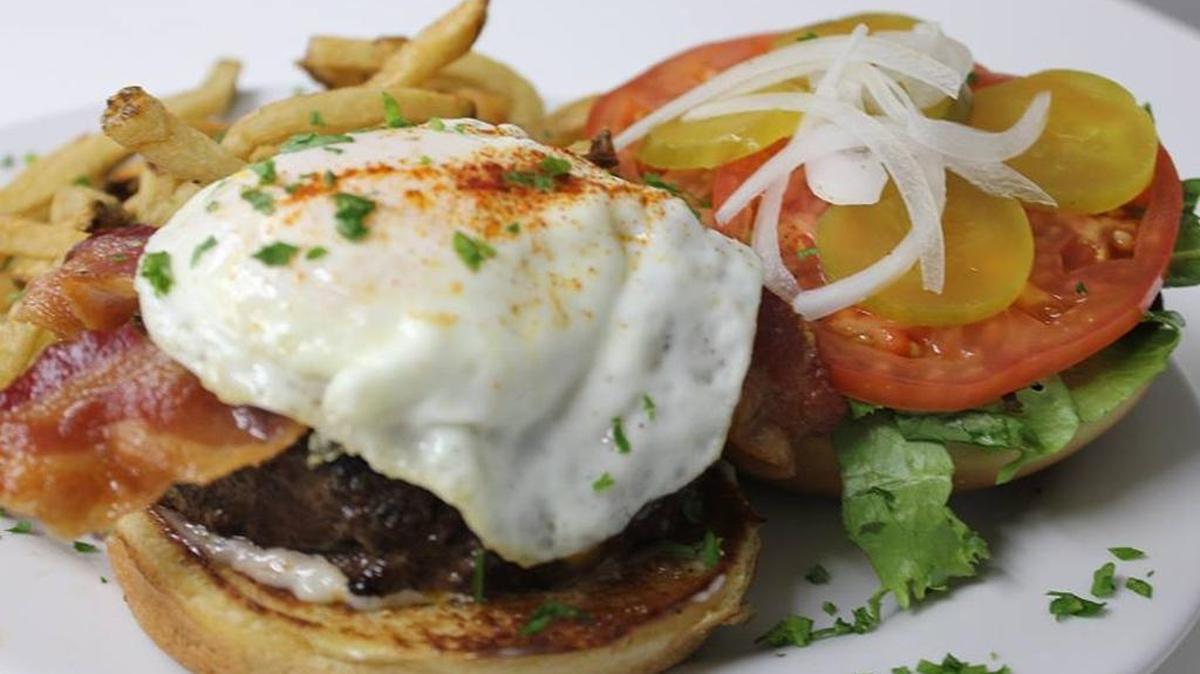 A hamburger topped with a fried egg adds a richness to the burger.