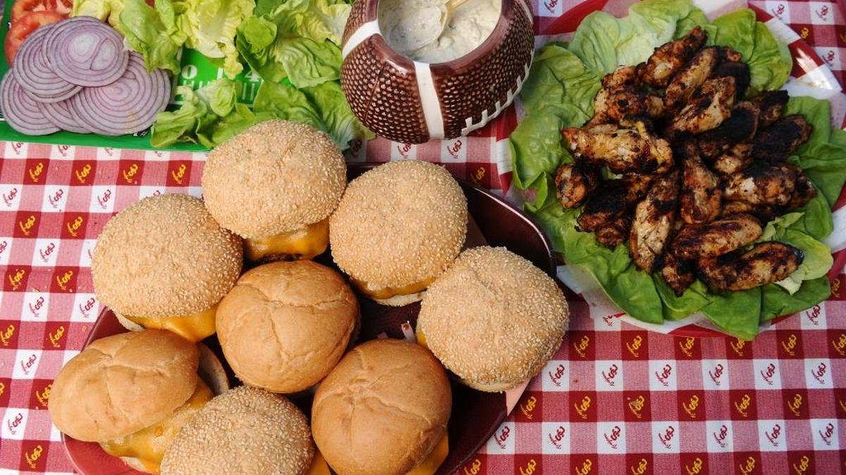 Burgers, chipotle chicken wings served with blue cheese dip at a USC tailgate party.