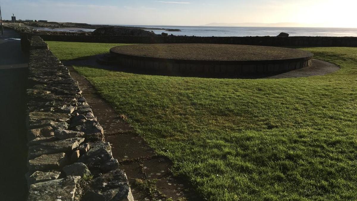 No wonder people want to climbthe wall. The other side of the wall mentioned on the Spiddal sign is a view of Galway Bay and its rocky beach. Even in winter Ireland clings to its green tradition.