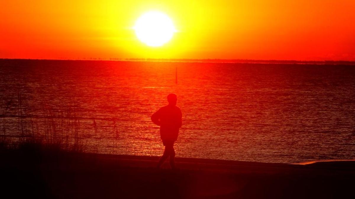 Dave Dessauer runs along the beach at sunrise on the Mississippi Gulf Coast.