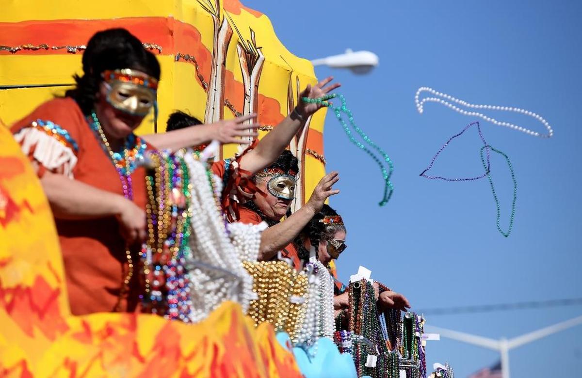 AMANDA McCOY/SUN HERALD Float riders throw beads to the crowd along U.S. 90 during the 48th annual Krewe of Nereids Mardi Gras parade on Sunday, February 8, 2015, in Waveland.