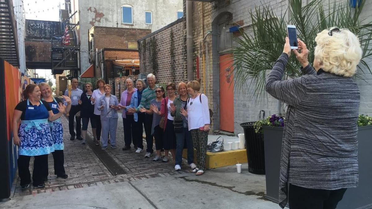 A group from the Osher Lifelong Learning Institute at the University of Southern Mississippi Gulf Park pose for a photo in Fishbone Alley along with Tasty Tours owners Wendy Fairley, left, and Jessica Adams earlier this year. It was part of the OLLI Downtown Gulfport Foodie Tour.
