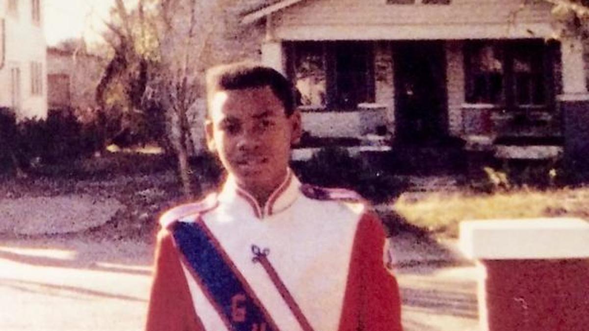 Standing in front of his family home on Thirty-First Street, Edward Evans Jr. is photographed in his Gulfport High School band uniform. In the background is the family home of pioneering aviator, John C. Robinson, ‘The Brown Condor.’