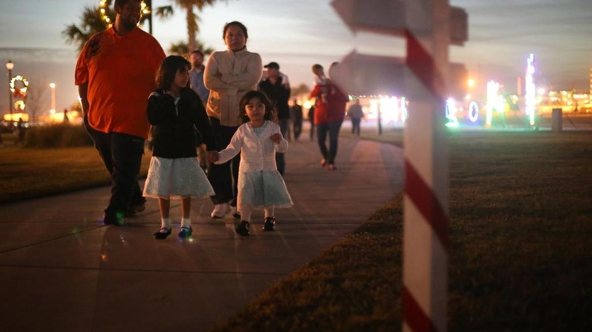 Families walk through Jones Park on the first night of the Gulfport Harbor Lights Winter Festival last year.