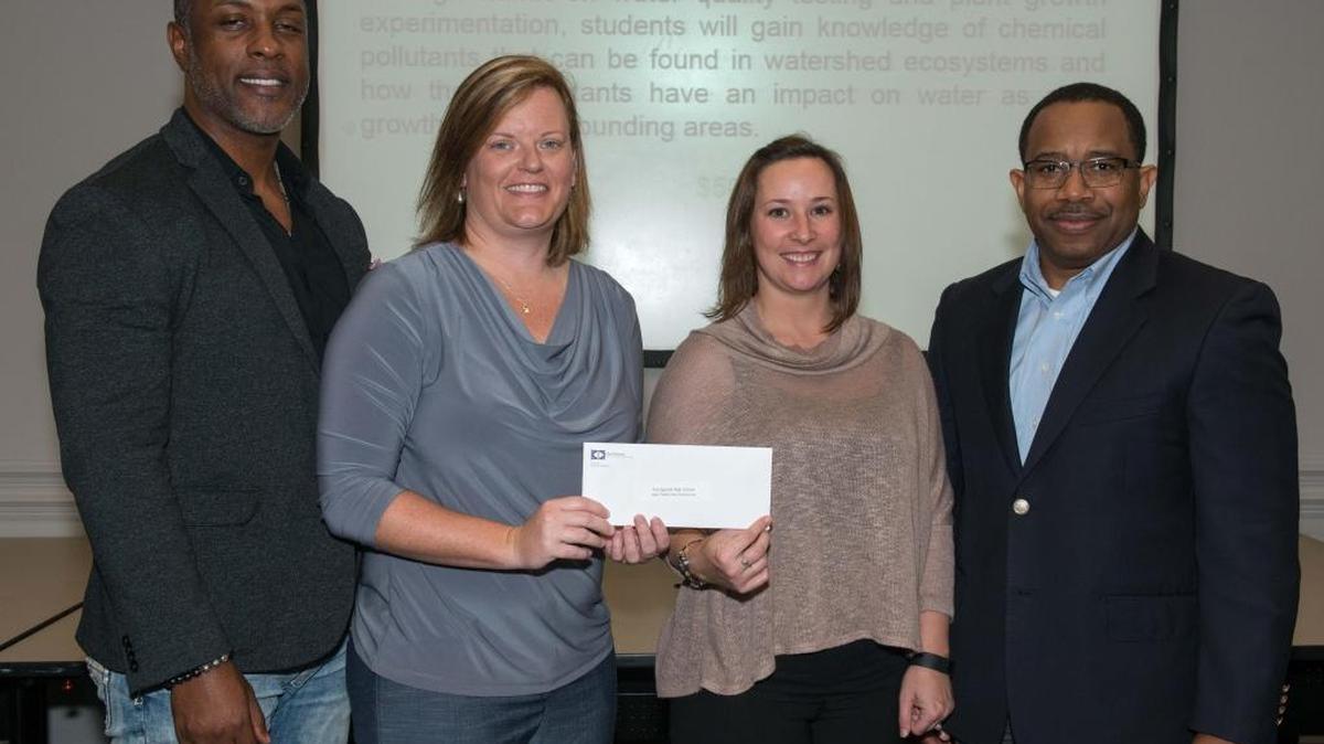 Edmond Hughes, right, vice president of human resources and administration at Ingalls Shipbuilding, presents a $5,000 STEM grant to Pascagoula High School Assistant Principal Prentiss Williams, left, and teachers Leigh Hanna and Victoria Waltman. The grant will allow students to conduct research on plant growth in watershed ecosystems.