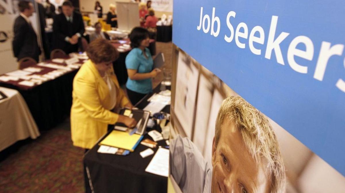In this Tuesday, July 10, 2012 photo, people walk by the recruiters at a jobs fair. Unemployment rose in June as students hit the job market on the Coast for the summer.