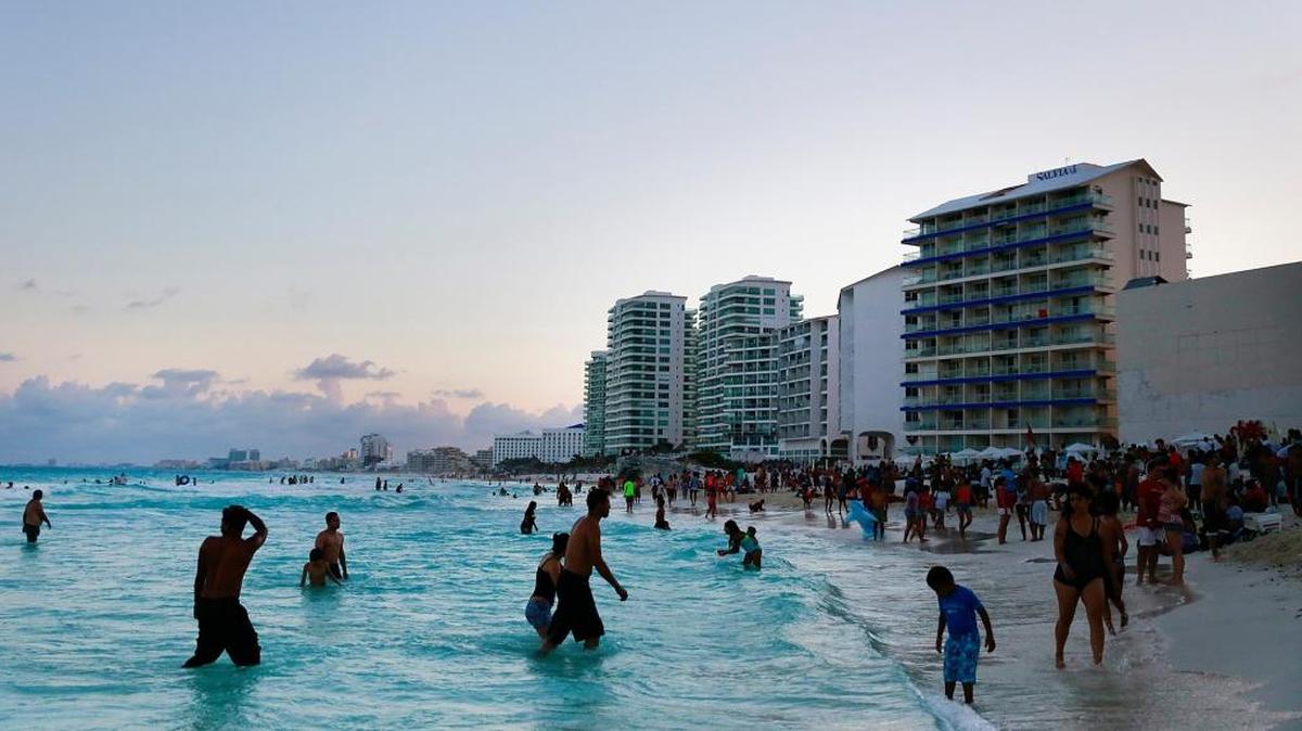 Beachgoers wade on the beach in Cancun, Mexico, on April 4, 2015.