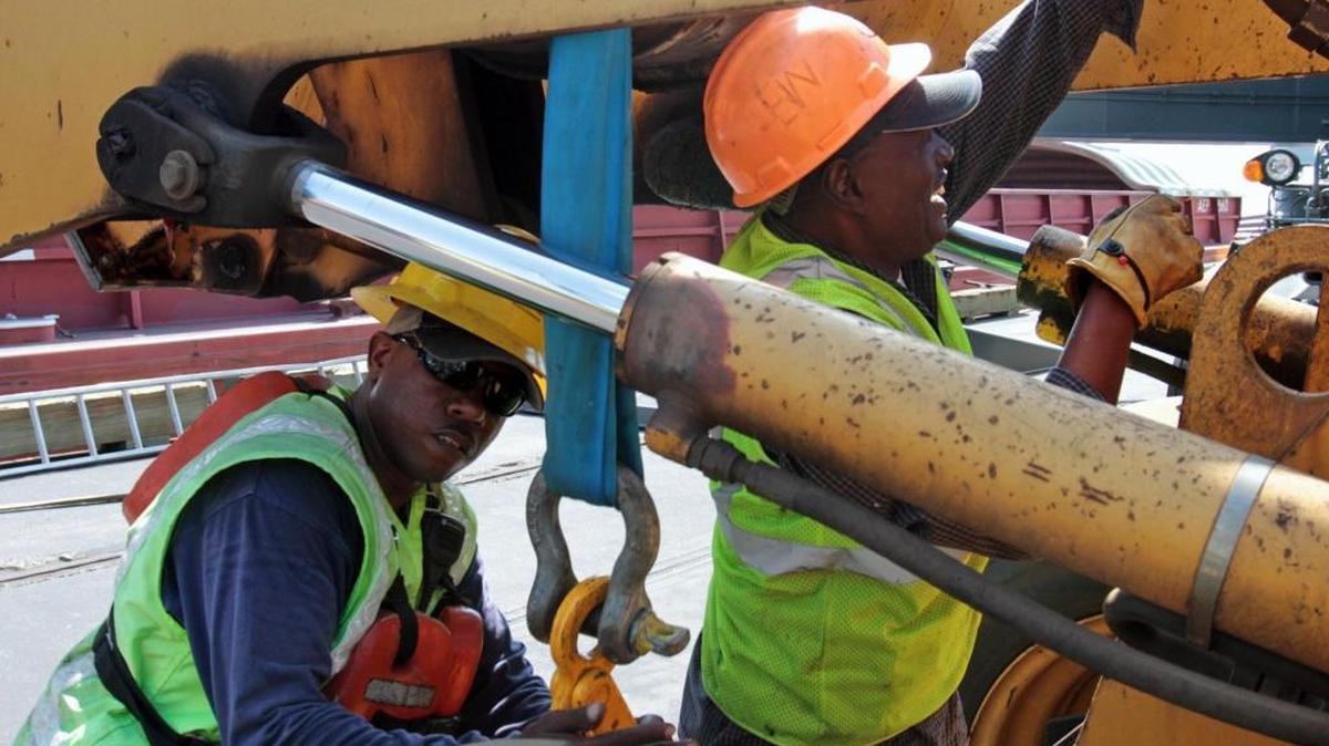 Longshoremen Anthony Williams, left, and William Elester, both of Gulfport, place covers on a barge after unloading ore for DuPont on the Port of Gulfport’s West Pier in 2012. A jobs report by CareerBuilders shows 60 percent of employers are looking to hire for full-time, permanent positions during the second half of 2017. The hot jobs are in IT, manufacturing, health care and financial services are the hot jobs. 