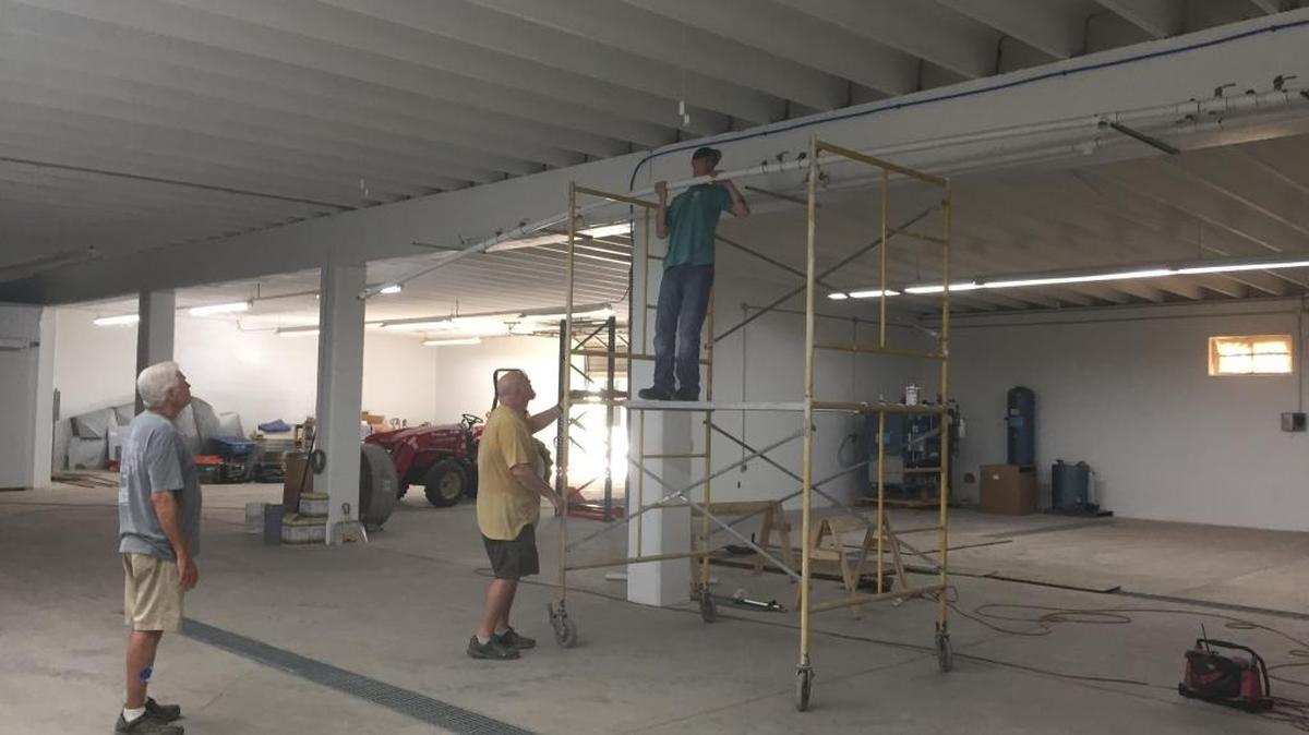 Co-owner Mark Murray, center, helps Hunter Murray suspend piping from the ceiling as Carlon Broome looks on at the new Biloxi Brewing Co. brewery in Biloxi on Nov. 3, 2016.