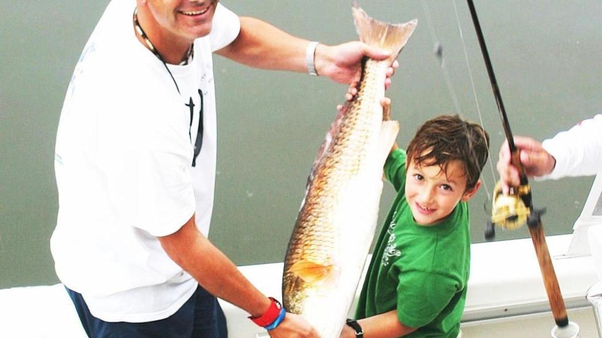 Shaggy’s co-owner Ron Ladner shows off a fish caught with Preston Bang at a kids fishing event.