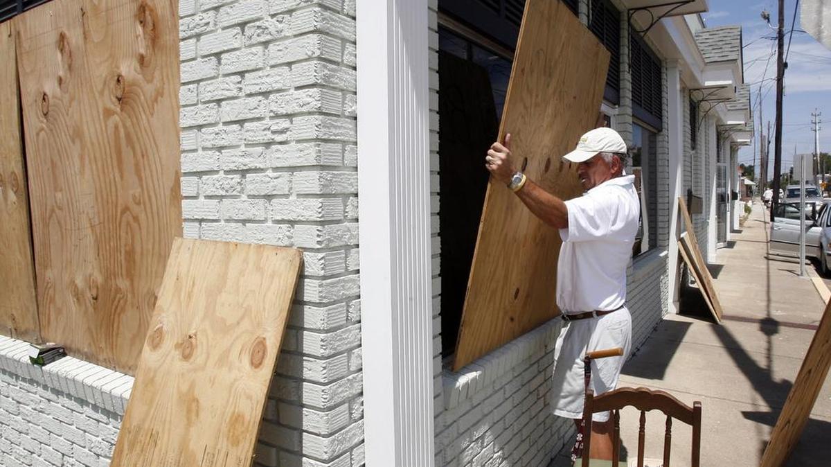 Keith Pisacrich boards up the windows to his office in downtown Biloxi in preparation of Tropical Storm and eventual Hurricane Isaac in 2012.