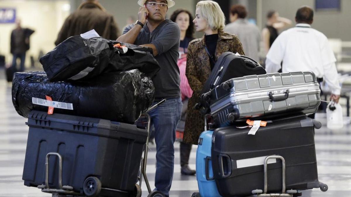 Travelers walk through terminal 3 baggage claim at O'Hare International airport in Chicago in 2013. Attorney General Jim Hood and attorneys general from 16 states are asking the U.S. Transportation Department to let consumers see up-front what fees they will be charged for baggage, selecting their seat and early boarding.