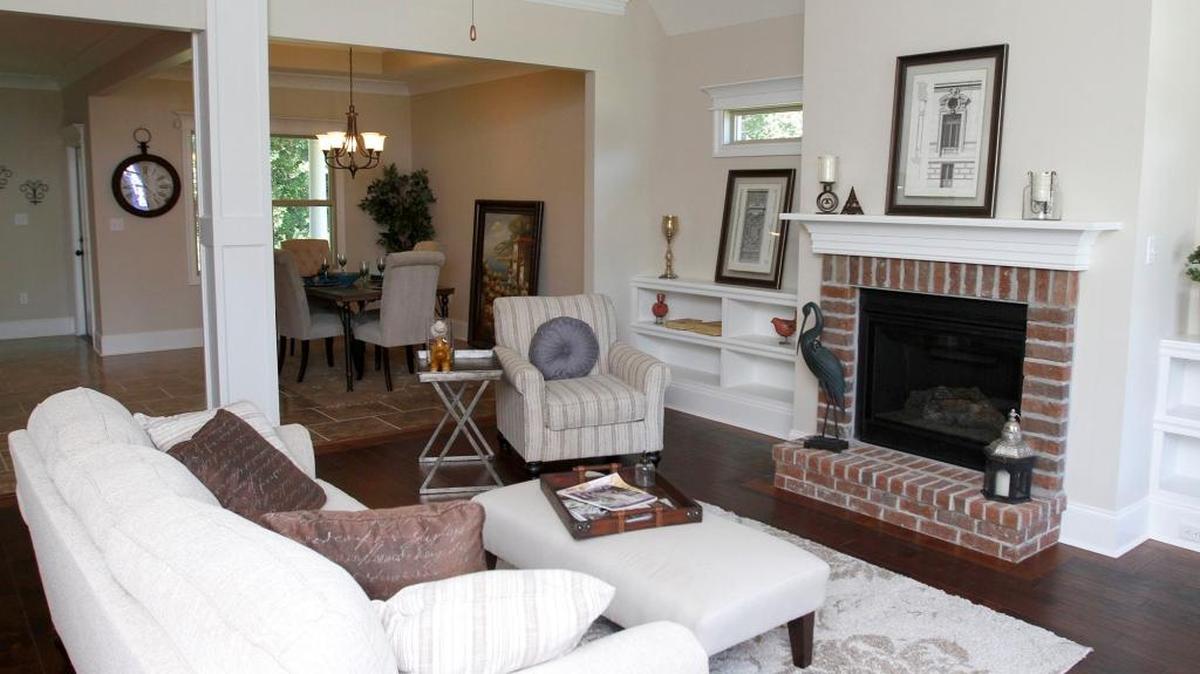 The open design of this Plantation Oaks home blends the dining room and living room, with a fireplace as a focal point.