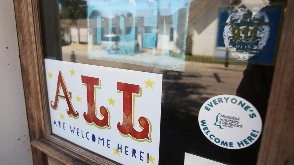 Bay St. Louis business owner Ann Madden printed signs that said 'ALL are welcome here!' in response to House Bill 1523 and handed them out to just about every business in Old Town Bay St. Louis. A sign can be seen in the window of Mockingbird Cafe in downtown Bay St. Louis.