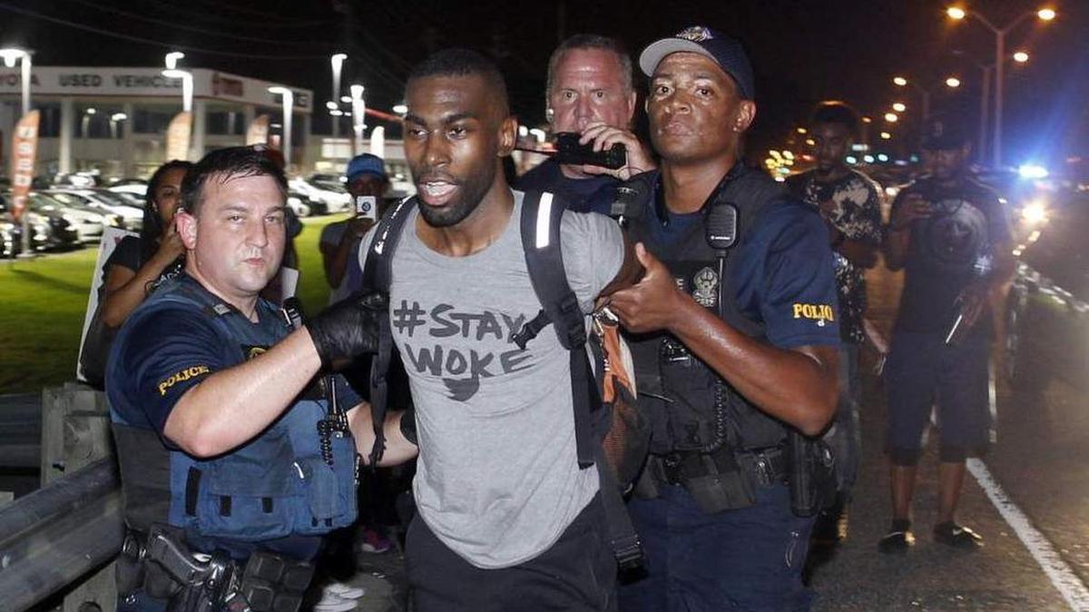 Police arrest activist DeRay McKesson during a protest along Airline Highway, a major road that passes in front of the Baton Rouge Police Department headquarters, on Saturday, July 9, 2016. Protesters were angry over the fatal shooting of Alton Sterling by two white Baton Rouge police officers.