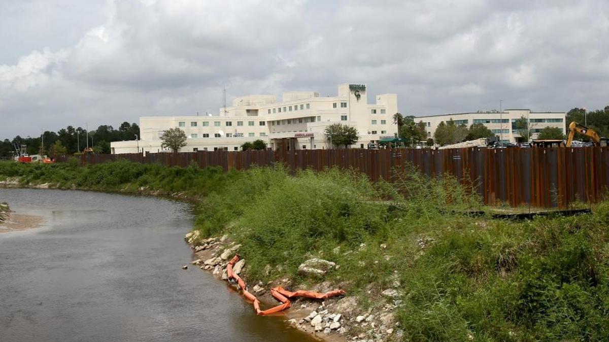 A flood wall is under construction, protecting Garden Park Medical Center from the Flat Branch in Gulfport.