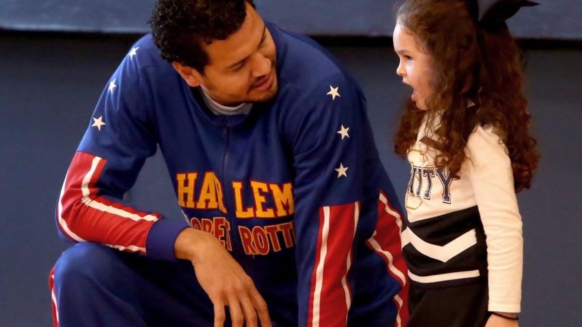 Harlem Globetrotter El Gato Melendez talks with Kate O'Grady during program at Nativity BVM Elementary school.