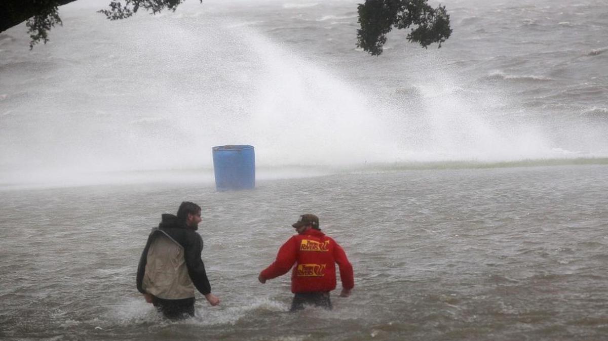 Two men walk in the storm surge from Isaac along Lake Pontchartrain as the storm approached landfall in New Orleans in 2012.