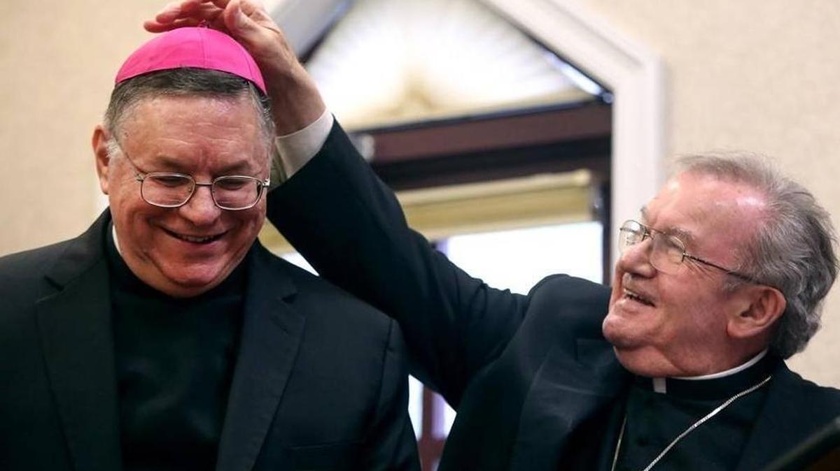The Catholic Diocese of Biloxi announced Wednesday the upcoming installation of Bishop-designate Louis Kihneman, shown here in December with the Most Rev. Roger Morin, has been postponed for medical reasons.