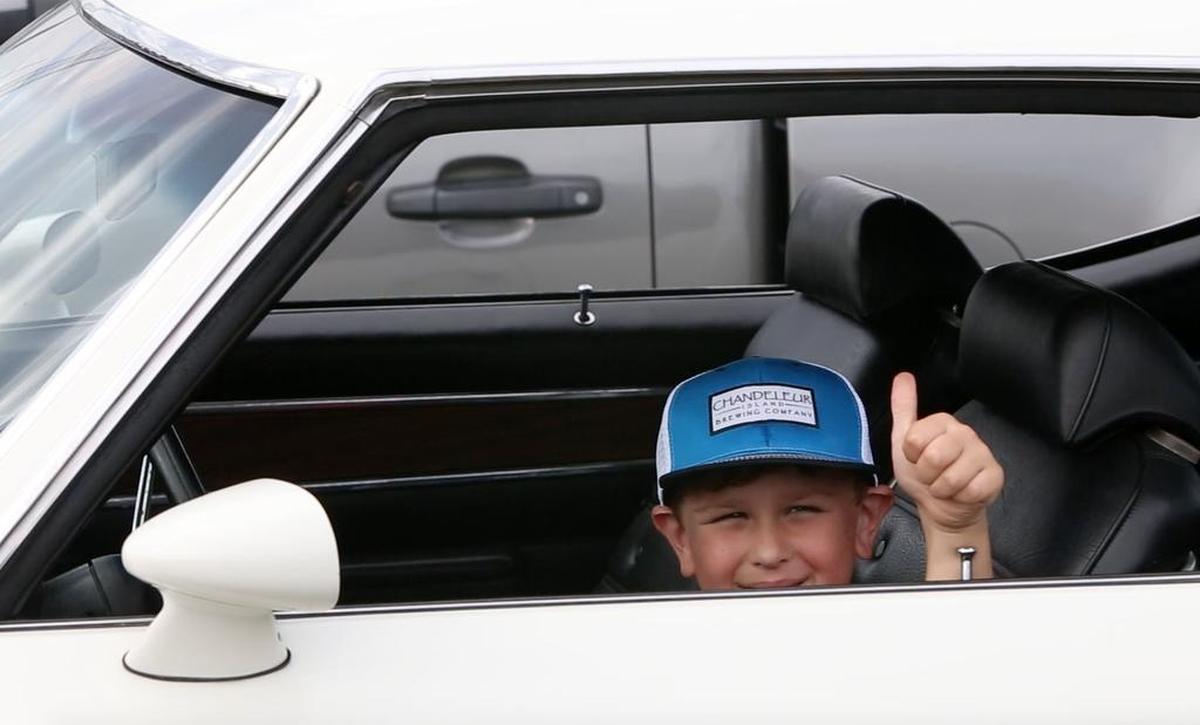 Fisher Roberds, 7, of Fairhope, Ala., poses for a photo in a friend's 1972 Oldsmobile 442 during Gulfport's View The Cruise on the first day of Cruisin' The Coast in 2016.