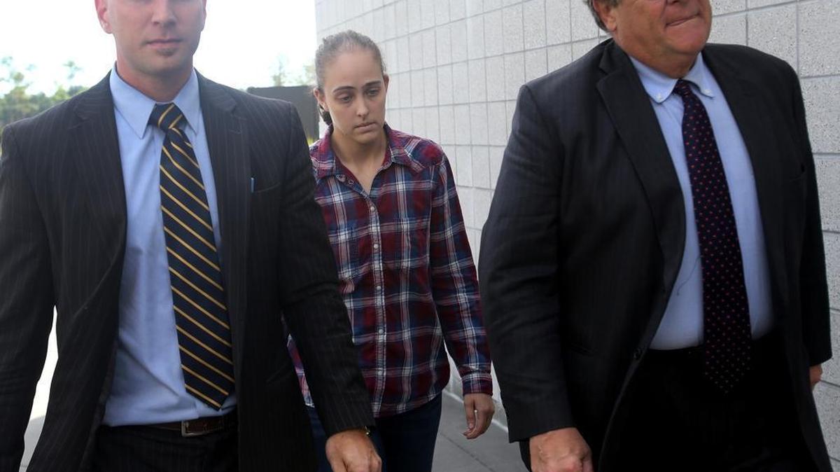Former Long Beach police officer Cassie Barker walks into the Hancock County Public Safety Complex with lawyers George Blair, left, and Donald Rafferty on Thursday. A warrant was issued for her arrest on a charge of manslaughter involved in the death of her daughter, Cheyenne Hyer, 3.