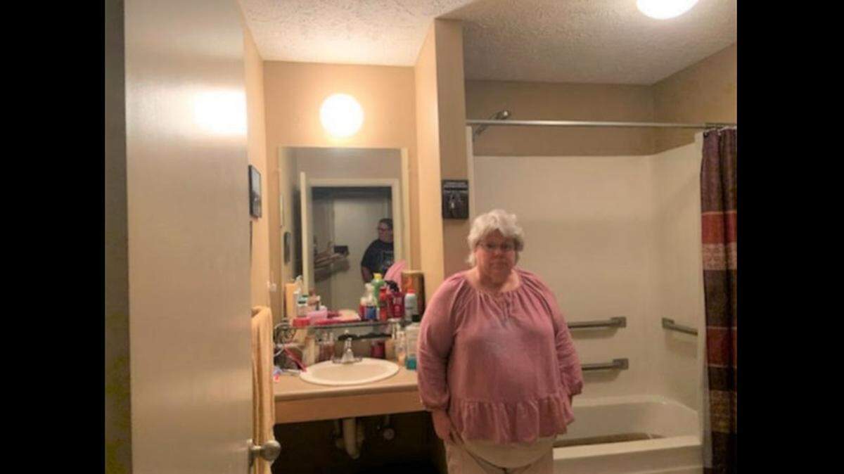Tenant Sabrina Dixon stands in front of a bathtub filled with raw sewage in her apartment at Bay Crossings Apartments in Hancock County, where toilets began backing up Friday night. The problem was not resolved until Tuesday evening.