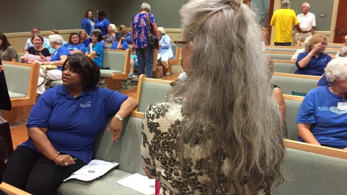 Hancock County Library System Executive Director Courtney Thomas waits for the meeting of the Board of Supervisors to begin. She’s surrounded by supporters wearing blue.