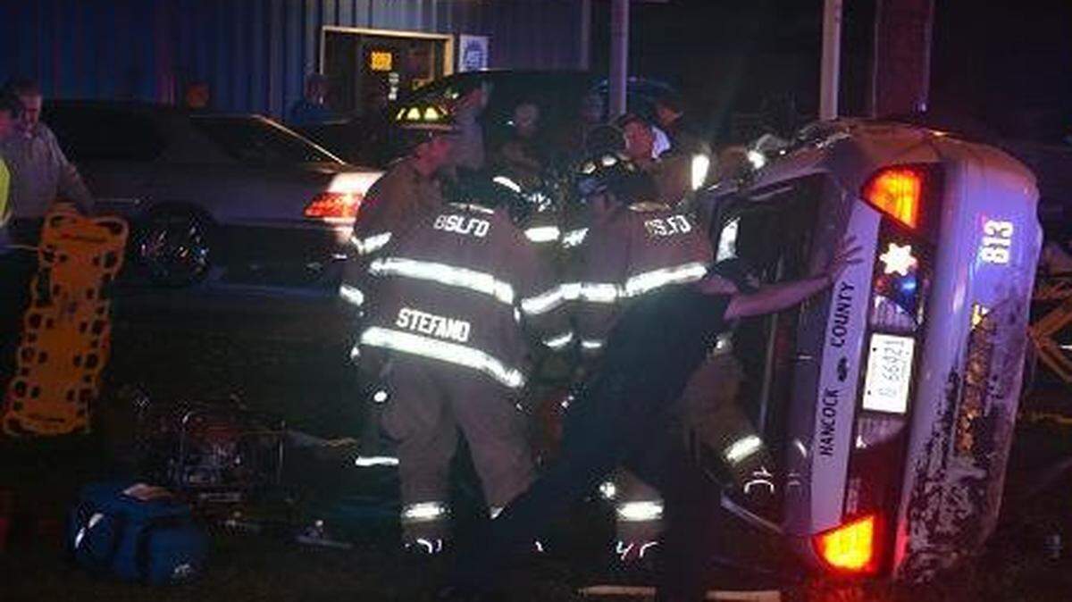 Police and fire personnel work to free a Hancock County Deputy who was involved in a crash Friday evening.