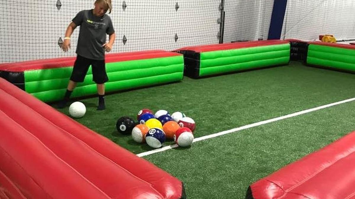 In one inflatable game, a player’s foot is the pool cue.