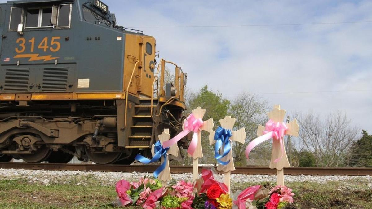 A CSX passes a memorial on Wednesday, March 8, 2017, near the site of Tuesday's fatal train-bus wreck at the Main Street railroad crossing where four bus passengers died. A candlelight vigil is planned for Sunday.