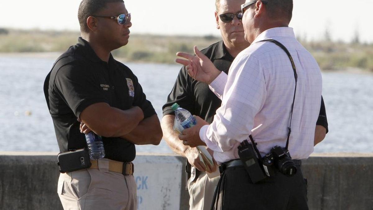 Chief of Marine Patrol Keith Davis, left, talks with officers at the Biloxi Small Craft Harbor on Thursday morning after emergency personnel retrieved a body from the water about 7:35 a.m.
